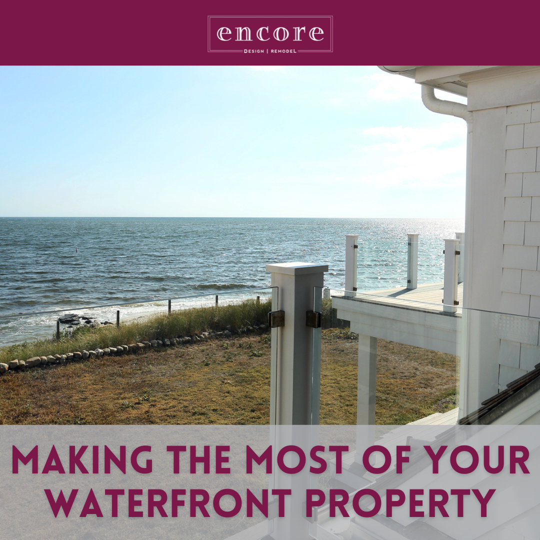 View of a Cape Cod-style coastal home with a glass-railed deck overlooking the ocean, used in a blog about designing and remodeling waterfront property with Encore Construction.